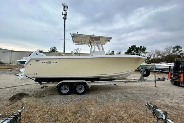 The Image of 2005 Sailfish 266 CC boat on trailer, parked outdoors under cloudy sky. - 0