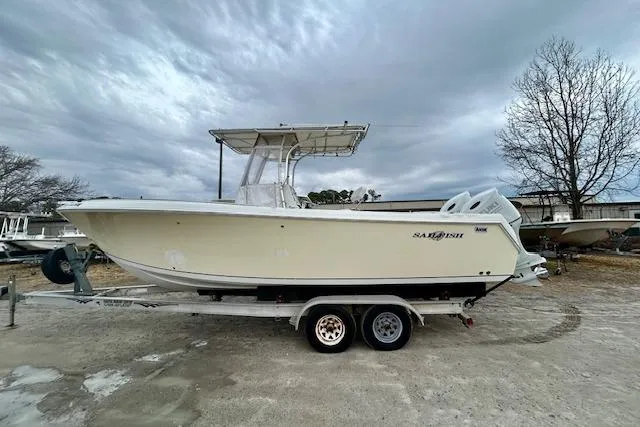 Slide: The Image of 2005 Sailfish 266 CC boat on trailer under cloudy sky. - 2