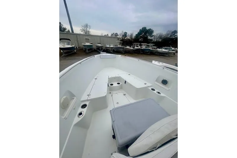 Slide: The Image of 2005 Sailfish 266 CC boat interior with seating and storage, docked among other boats. - 10