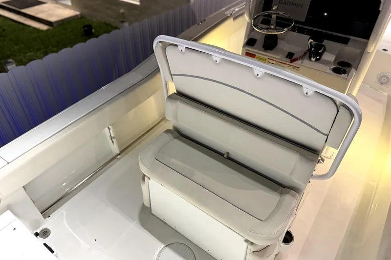 Slide: The Image of 2024 Sea Hunt Ultra 239 SE boat interior with cushioned seating and control panel. - 15