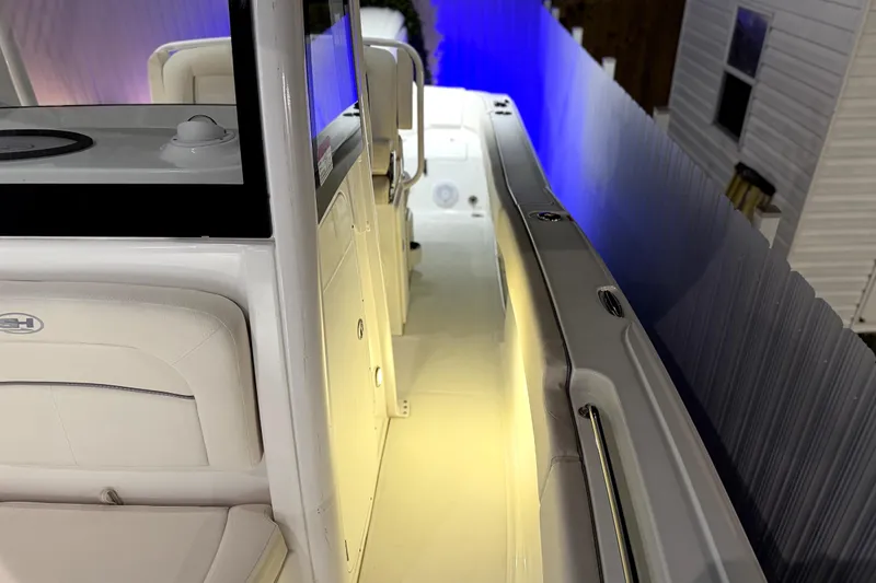 Slide: The Image of 2024 Sea Hunt Ultra 239 SE boat interior with ambient lighting and seating. - 18