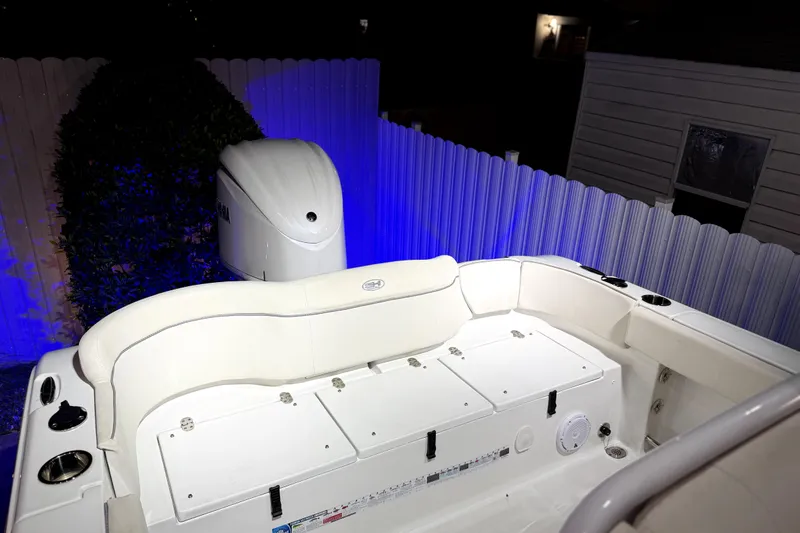 Slide: The Image of 2024 Sea Hunt Ultra 239 SE boat interior with Yamaha engine, illuminated by blue light. - 21