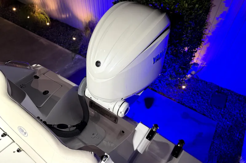 Slide: The Image of 2024 Sea Hunt Ultra 239 SE boat with Yamaha outboard motor, illuminated by blue lighting. - 22