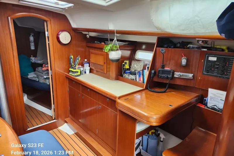 Slide: The Image of Interior of 2005 Beneteau Oceanis Clipper 393 sailboat with wooden cabinetry and navigation equipment. - 13