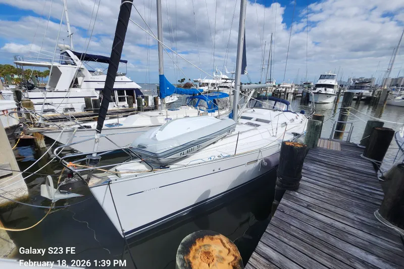 Slide: The Image of 2005 Beneteau Oceanis Clipper 393 sailboat docked at marina under cloudy sky. - 2
