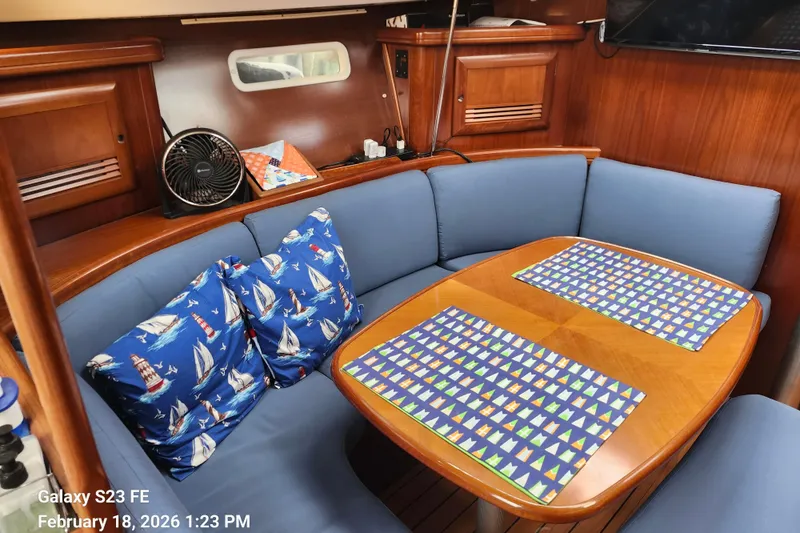 Slide: The Image of Cozy interior of 2005 Beneteau Oceanis Clipper 393 with nautical-themed cushions and wooden table. - 9