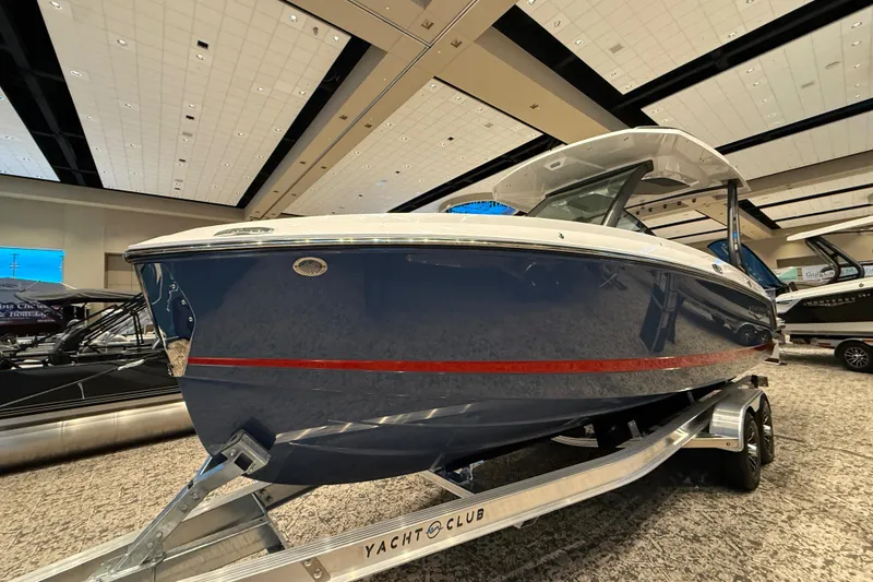 Slide: The Image of 2026 Monterey Elite 25 OB boat displayed indoors on a trailer. - 2