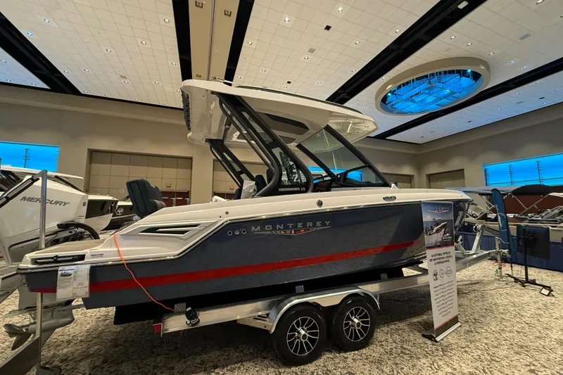 Slide: The Image of 2026 Monterey Elite 25 OB boat displayed indoors on a trailer. - 3
