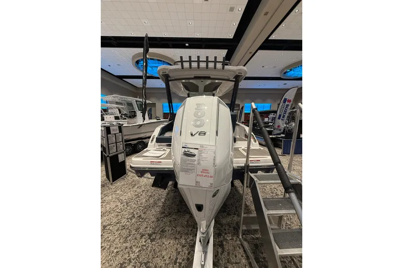 Slide: The Image of 2026 Monterey Elite 25 OB boat displayed indoors with V8 engine. - 4