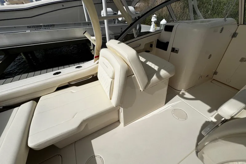 Slide: The Image of 2026 Grady-White Freedom 235 boat interior with beige seating and storage compartments. - 19