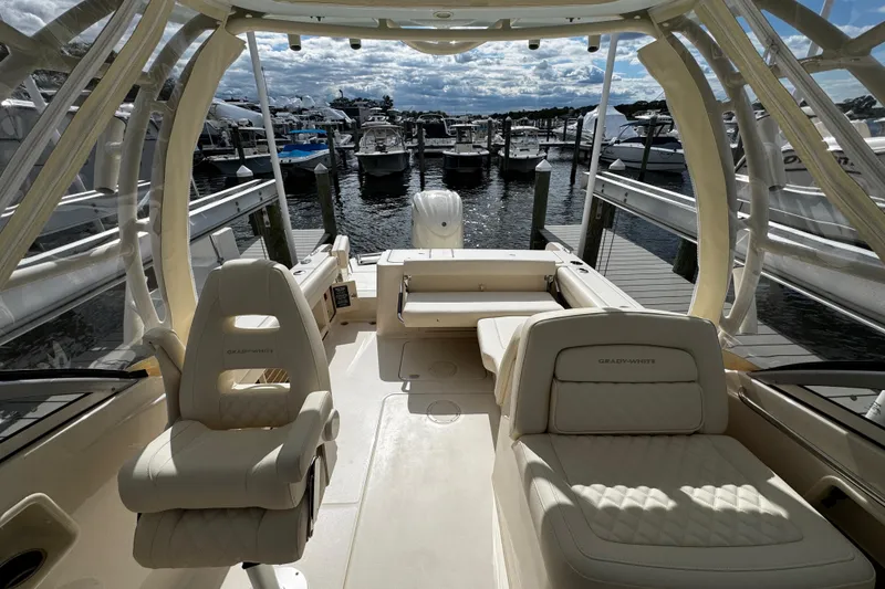 Slide: The Image of 2026 Grady-White Freedom 235 boat interior at marina, featuring luxurious seating and elegant design. - 21