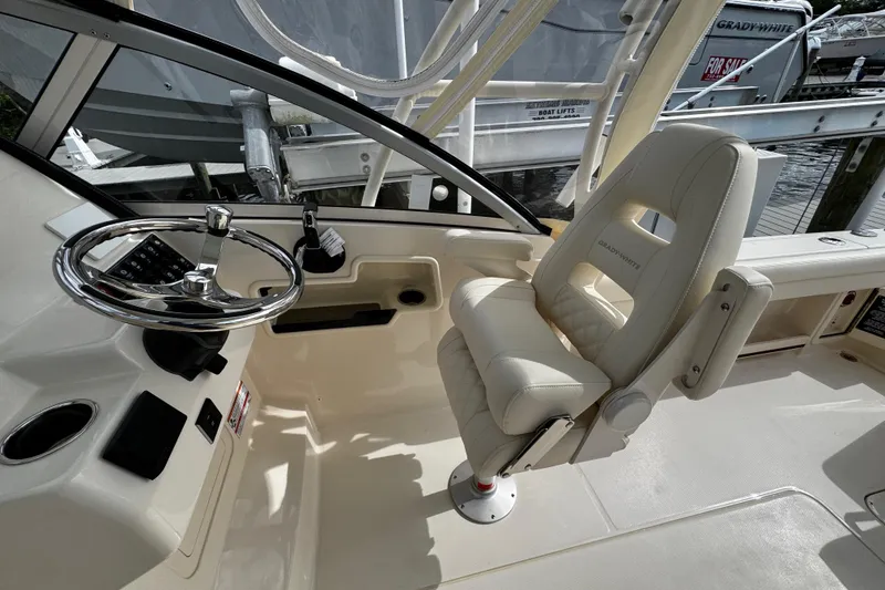 Slide: The Image of 2026 Grady-White Freedom 235 boat interior with steering wheel and captain's chair. - 22