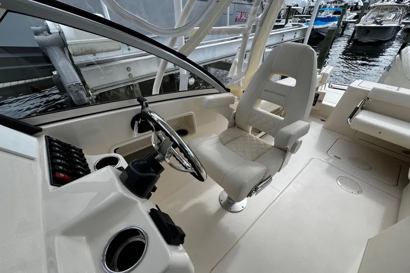 Slide: The Image of Interior of a 2026 Grady-White Freedom 235 boat, featuring a sleek captain's chair and control panel. - 28