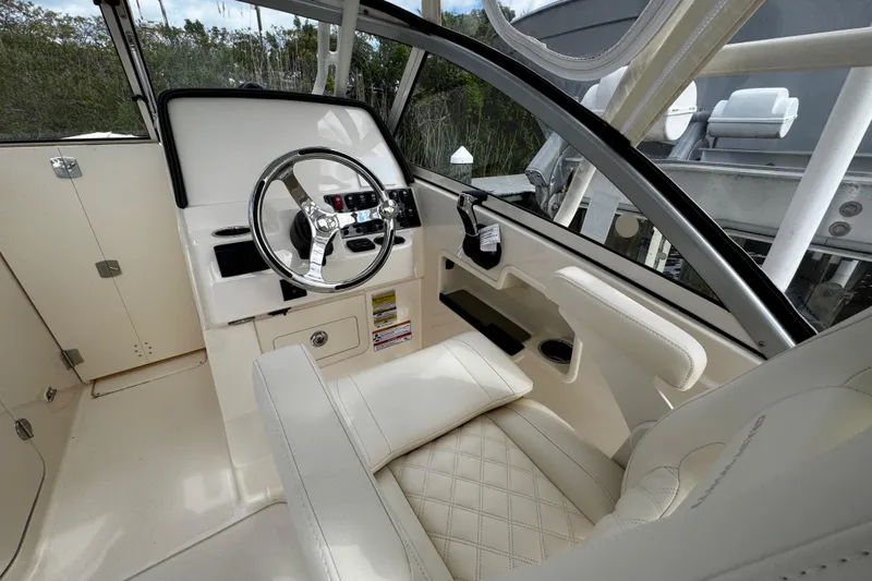 Slide: The Image of 2026 Grady-White Freedom 235 boat interior with steering wheel and luxurious seating. - 29