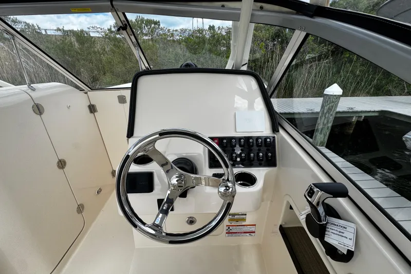 Slide: The Image of 2026 Grady-White Freedom 235 boat helm with steering wheel and control panel. - 30