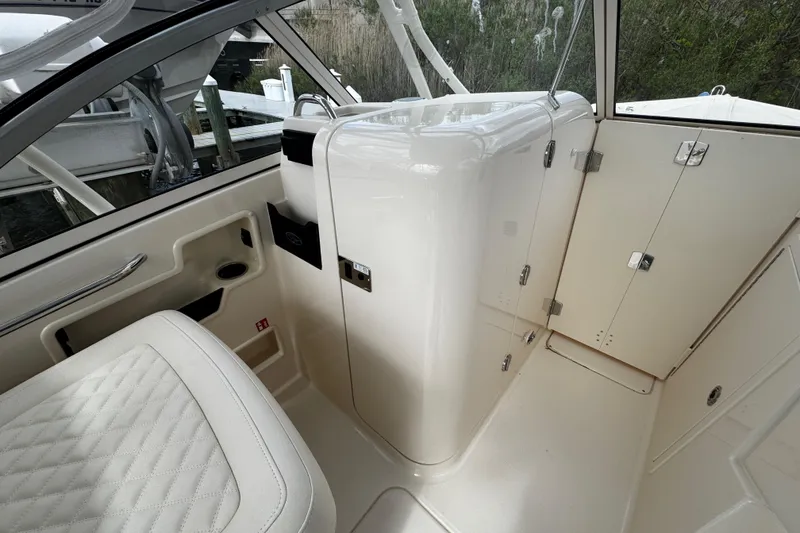 Slide: The Image of Interior of 2026 Grady-White Freedom 235 boat, featuring sleek white seating and cabinetry. - 32