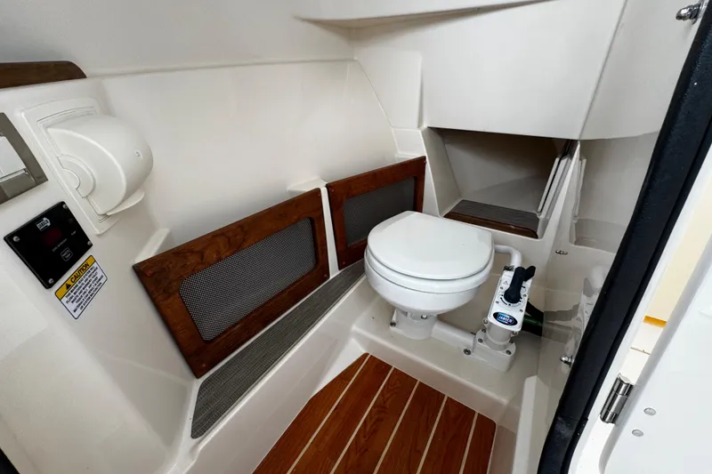 Slide: The Image of Interior of 2026 Grady-White Freedom 235 boat featuring a compact marine toilet. - 35