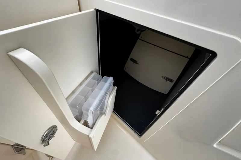 Slide: The Image of Storage compartment on a 2026 Grady-White Freedom 235 boat with organized containers. - 36