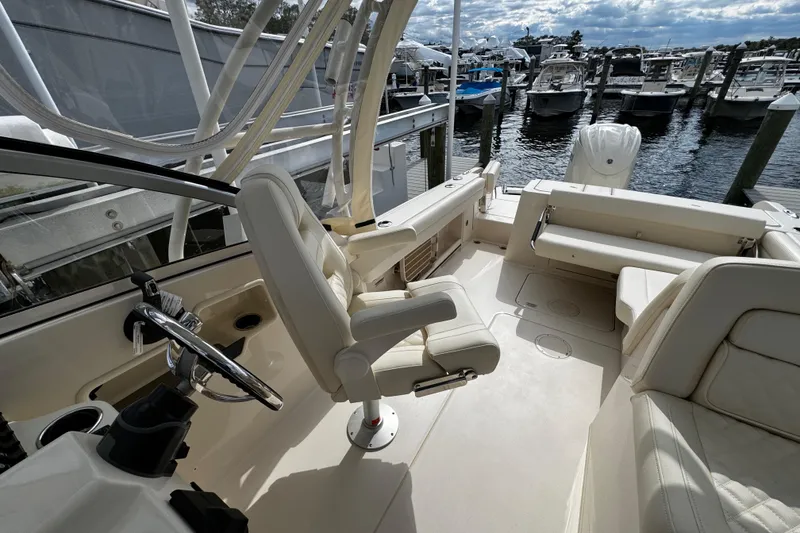 Slide: The Image of 2026 Grady-White Freedom 235 boat interior at marina, featuring helm and seating area. - 39