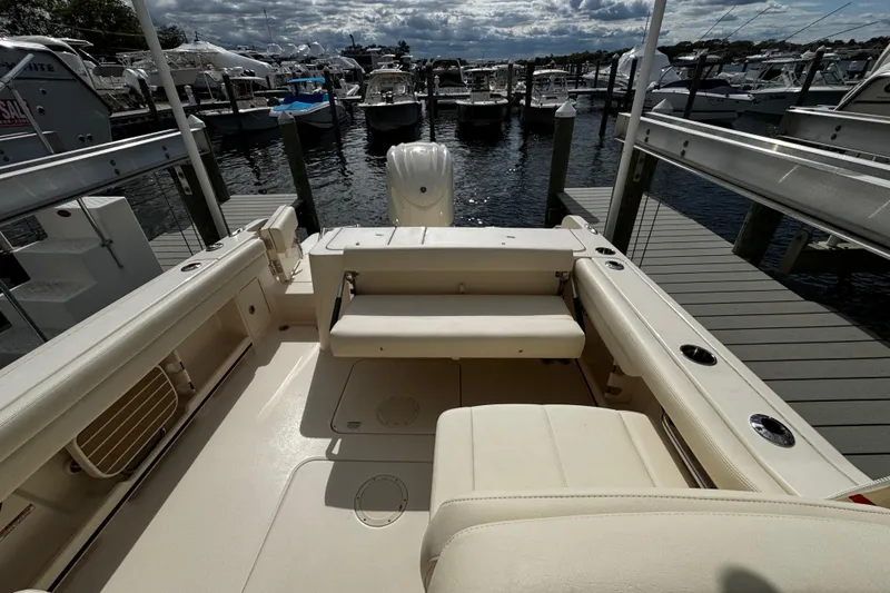 Slide: The Image of 2026 Grady-White Freedom 235 boat interior at marina, showcasing seating and docked boats. - 40