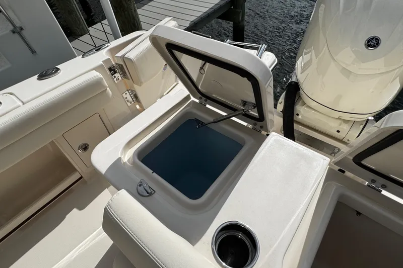 Slide: The Image of 2026 Grady-White Freedom 235 boat interior with open storage compartment and cup holder. - 43