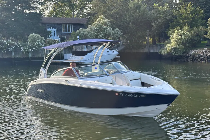 The Image of 2021 Cobalt R3 boat cruising on a calm river near a house and trees. - 0