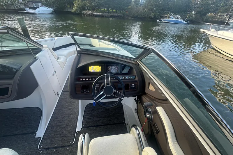 Slide: The Image of 2021 Cobalt R3 boat interior with steering wheel and dashboard on a calm river. - 15