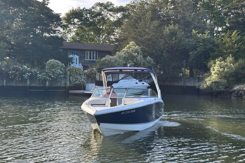 Slide: The Image of 2021 Cobalt R3 boat cruising on a serene lake near a wooded shoreline. - 3