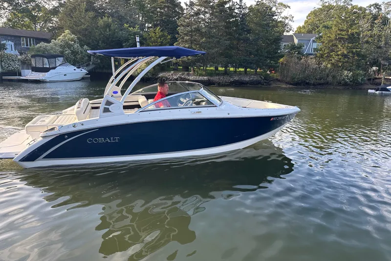 Slide: The Image of 2021 Cobalt R3 boat cruising on a calm river with trees in the background. - 4