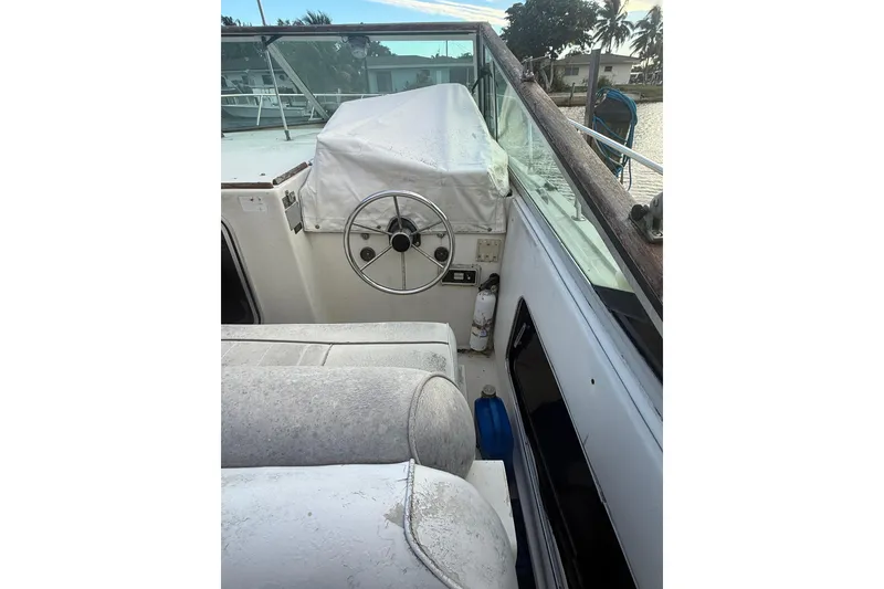 Slide: The Image of 1986 Chris-Craft 336 Commander boat helm with covered steering wheel and seating area. - 10