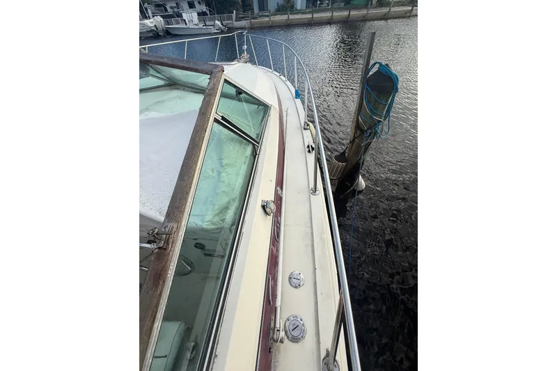 Slide: The Image of 1986 Chris-Craft 336 Commander boat docked, showcasing deck and railing details. - 20