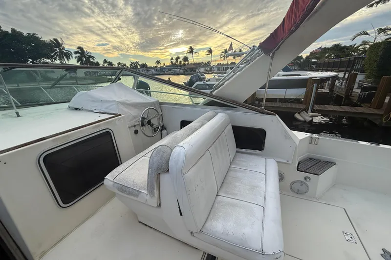 Slide: The Image of 1986 Chris-Craft 336 Commander boat interior with seating, docked at sunset. - 21