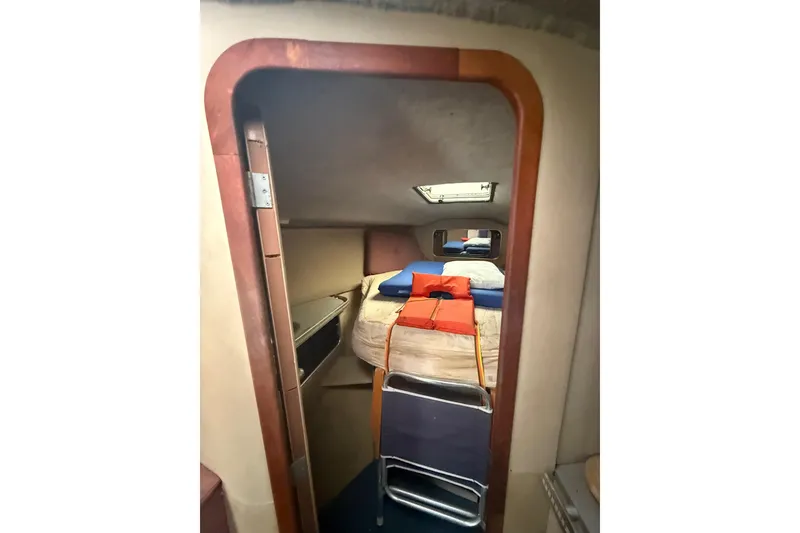 Slide: The Image of 1986 Chris-Craft 336 Commander cabin interior with bed and life jackets. - 23