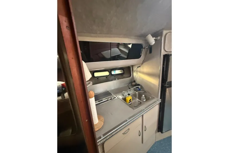 Slide: The Image of 1986 Chris-Craft 336 Commander interior kitchen with sink and storage. - 25