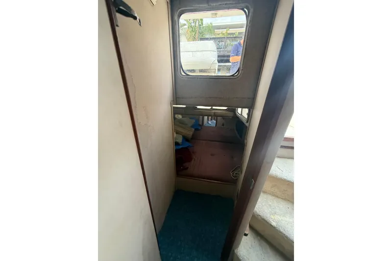 Slide: The Image of Interior cabin of 1986 Chris-Craft 336 Commander boat, featuring a small window and seating area. - 27