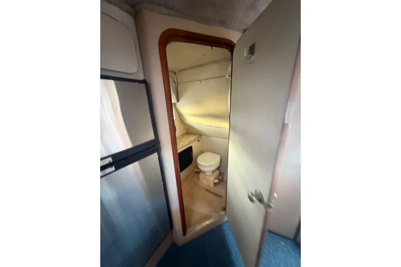 Slide: The Image of 1986 Chris-Craft 336 Commander boat interior showing compact bathroom with toilet. - 28