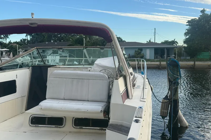 Slide: The Image of 1986 Chris-Craft 336 Commander docked by waterfront, featuring spacious seating and clear skies. - 4