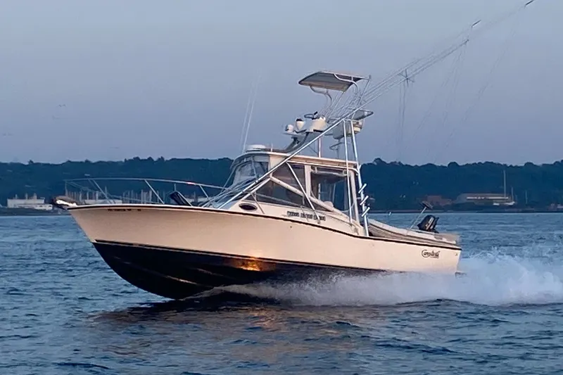 The Image of 2004 Carolina Classic 28 boat cruising on water at sunset. - 0