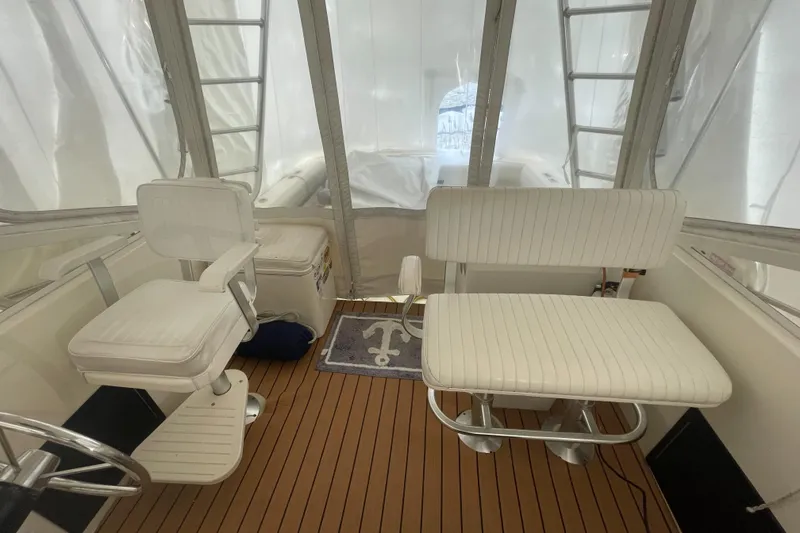 Slide: The Image of Interior of a 2004 Carolina Classic 28 boat with white seating and wooden flooring. - 11