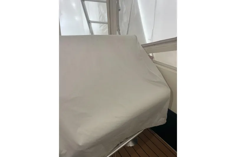 Slide: The Image of Covered helm of a 2004 Carolina Classic 28 boat, indoors with white tarp. - 13