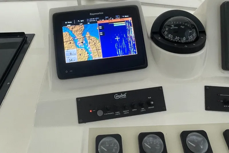 Slide: The Image of Control panel of a 2004 Carolina Classic 28 boat with navigation display and compass. - 19