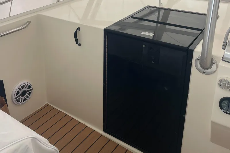 Slide: The Image of 2004 Carolina Classic 28 boat interior with black storage compartment and speaker. - 27