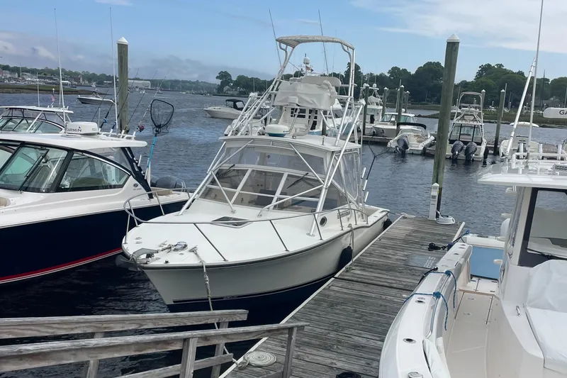 Slide: The Image of 2004 Carolina Classic 28 boat docked at a marina with other vessels. - 3
