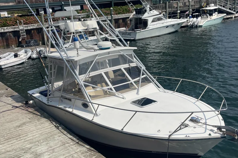 Slide: The Image of 2004 Carolina Classic 28 boat docked at marina, featuring sleek design and sturdy build. - 4