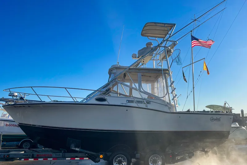 Slide: The Image of 2004 Carolina Classic 28 boat on trailer, clear blue sky background. - 56
