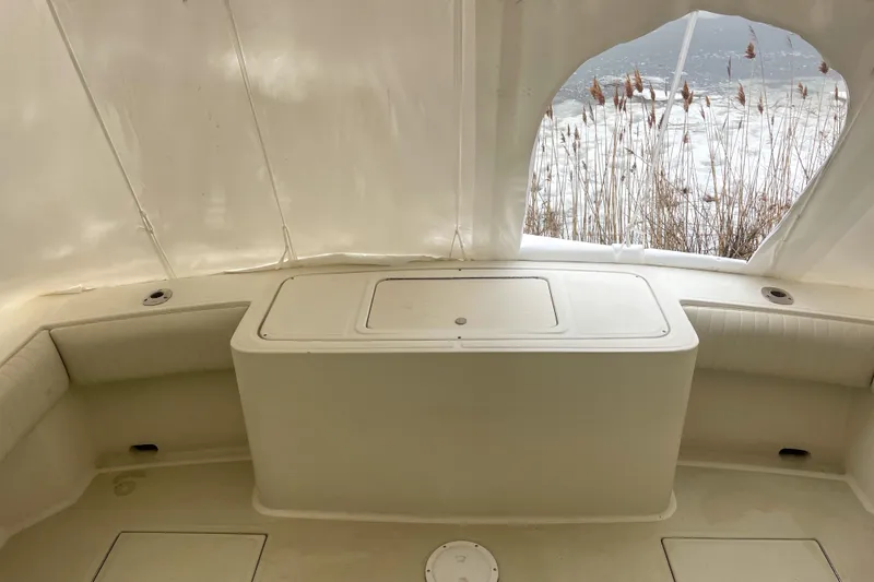 Slide: The Image of 2004 Carolina Classic 28 boat interior with seating and storage, overlooking a snowy landscape. - 7
