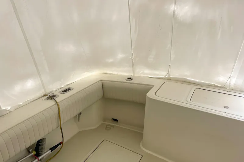 Slide: The Image of 2004 Carolina Classic 28 boat interior with white seating and storage compartments. - 9