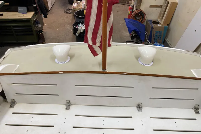 Slide: The Image of 1997 Wasque C.W.Hood Wasque 26 boat deck with American flag in workshop setting. - 11