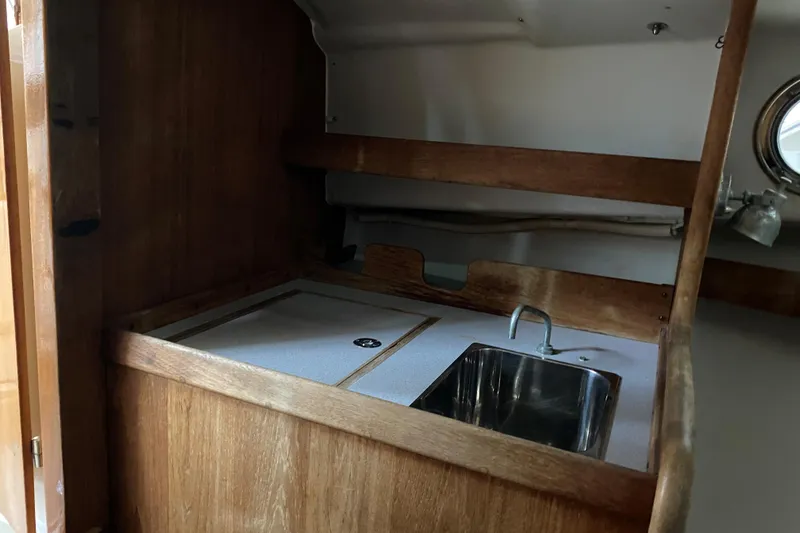 Slide: The Image of 1997 Wasque C.W.Hood Wasque 26 boat interior with wooden cabinetry and stainless steel sink. - 14