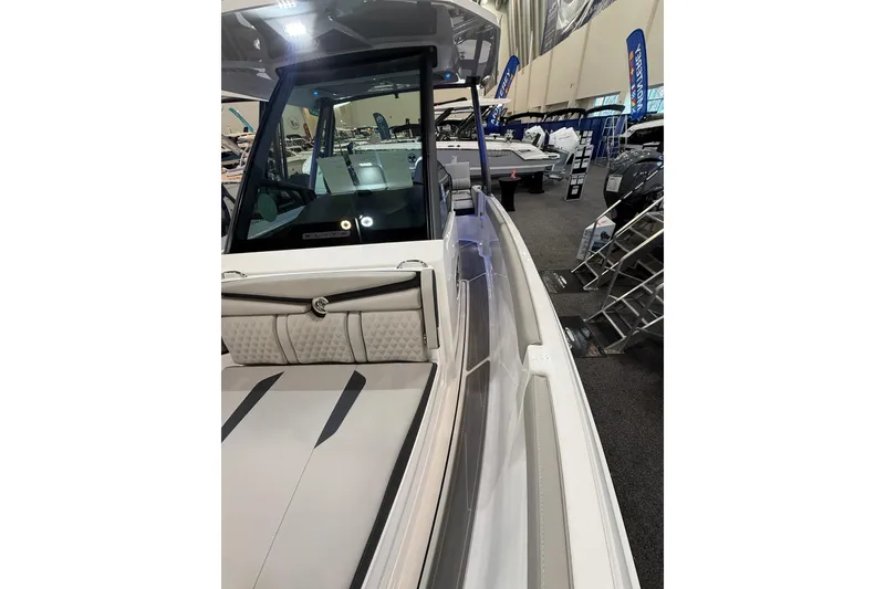 Slide: The Image of 2026 Monterey Elite 25 OB boat interior at a showroom, featuring sleek seating and modern design. - 15